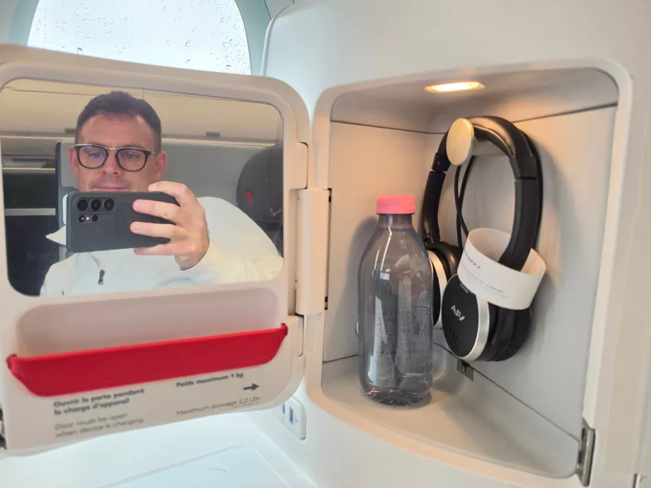 Et speil, hodetelefoner og en flaske vann