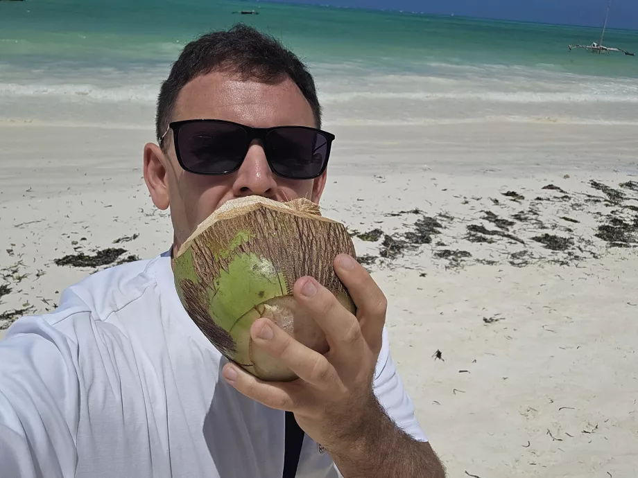 Jeg drikker kokosnøtt på stranden i Paje